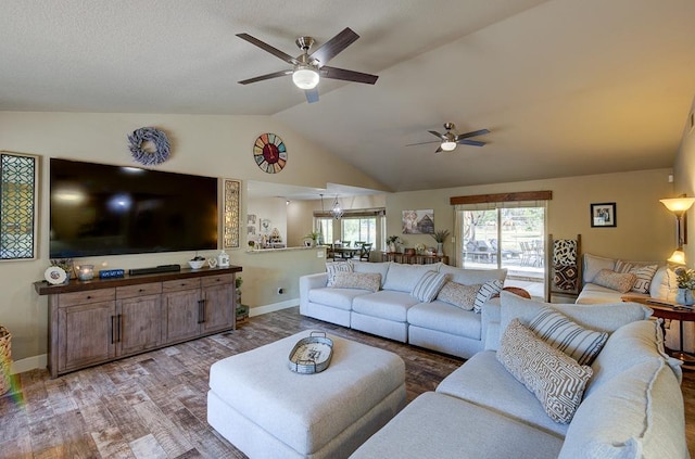 living room with a ceiling fan, lofted ceiling, baseboards, and wood finished floors