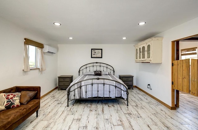 bedroom with baseboards, recessed lighting, light wood-style flooring, and a wall unit AC