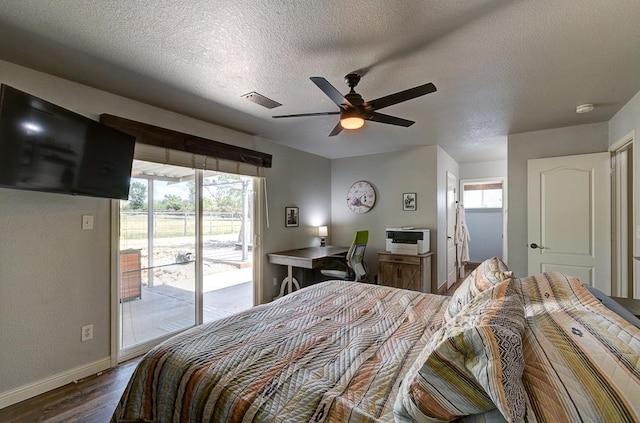 bedroom with access to exterior, a textured ceiling, dark wood-type flooring, baseboards, and visible vents