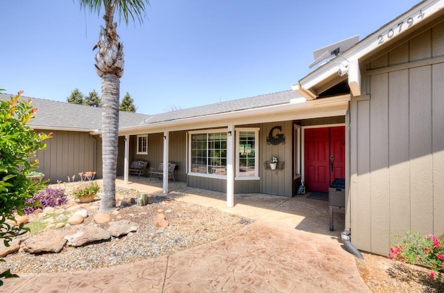 view of exterior entry with a patio area