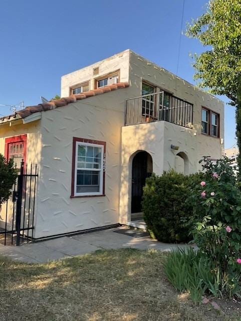 view of front of home featuring stucco siding and a balcony