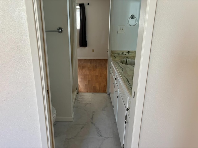 bathroom with vanity, marble finish floor, baseboards, and toilet