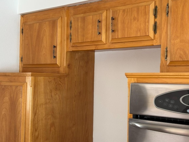 details featuring electric range oven and brown cabinets