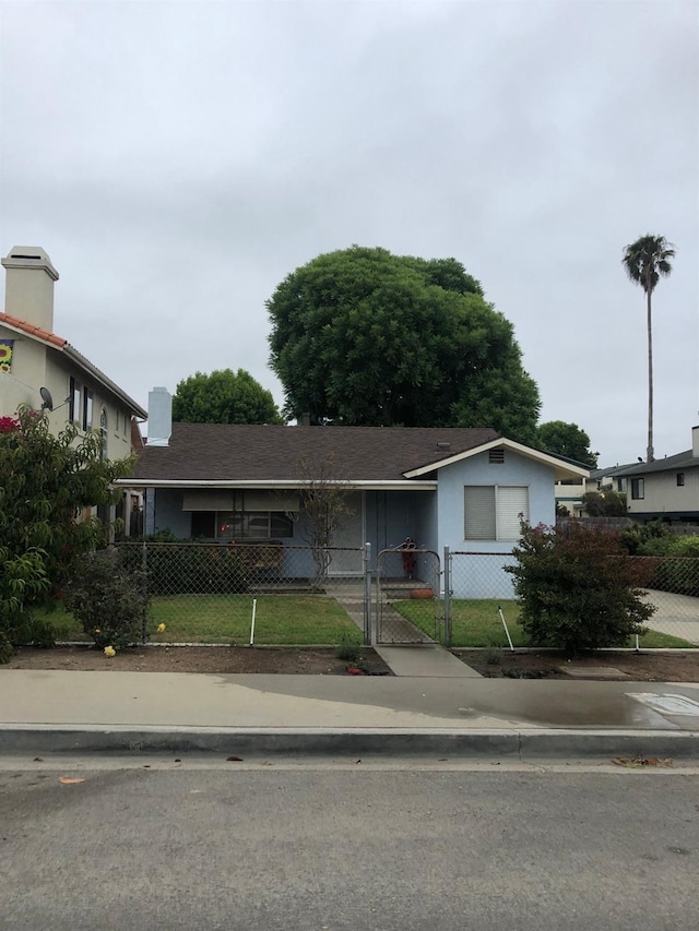 single story home featuring a fenced front yard and a gate