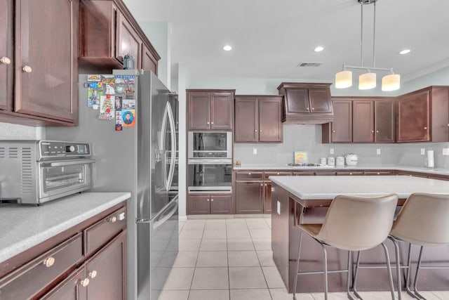 2776 Keats Ave, Clovis, CA 93611 - kitchen featuring oven, visible vents, light countertops, a kitchen bar, and built in microwave