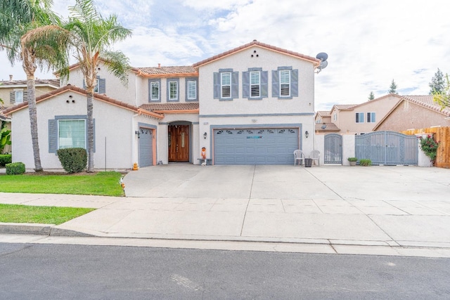 2776 Keats Ave, Clovis, CA 93611 - mediterranean / spanish-style home featuring a gate, a tile roof, an attached garage, and driveway