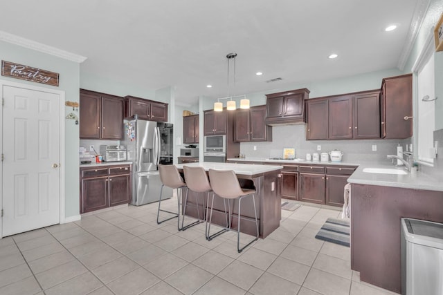 2776 Keats Ave, Clovis, CA 93611 - kitchen featuring a sink, decorative backsplash, a kitchen bar, a center island, and appliances with stainless steel finishes