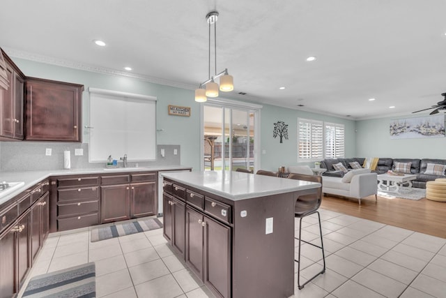 2776 Keats Ave, Clovis, CA 93611 - kitchen with a sink, ornamental molding, a breakfast bar, and light tile patterned floors