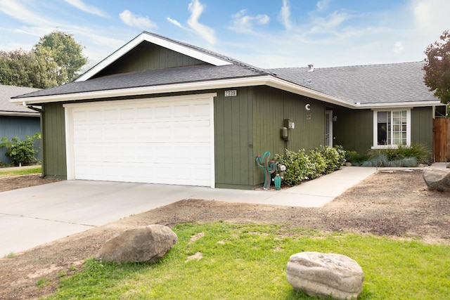 view of front of home featuring concrete driveway, a shingled roof, and an attached garage