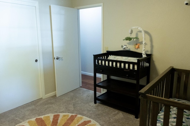 bedroom featuring carpet and a nursery area