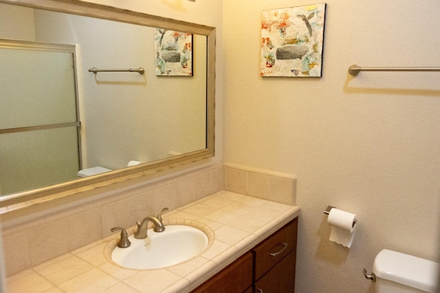bathroom with toilet, a shower with shower door, tasteful backsplash, and vanity
