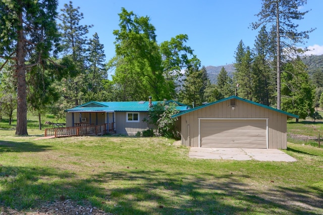 back of house featuring a yard, a mountain view, an outdoor structure, and a garage