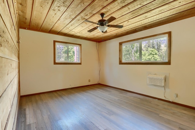 unfurnished room featuring a ceiling fan, an AC wall unit, baseboards, wood ceiling, and wood finished floors