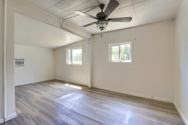 spare room featuring baseboards, vaulted ceiling, ceiling fan, and wood finished floors
