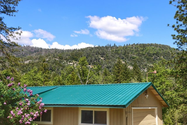 exterior space featuring metal roof and a view of trees