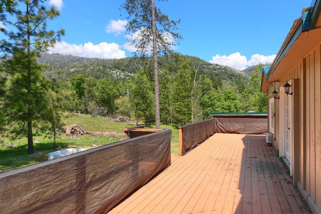 wooden deck featuring a view of trees and a mountain view