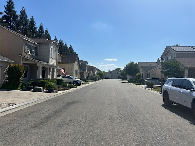 view of street featuring a residential view and curbs
