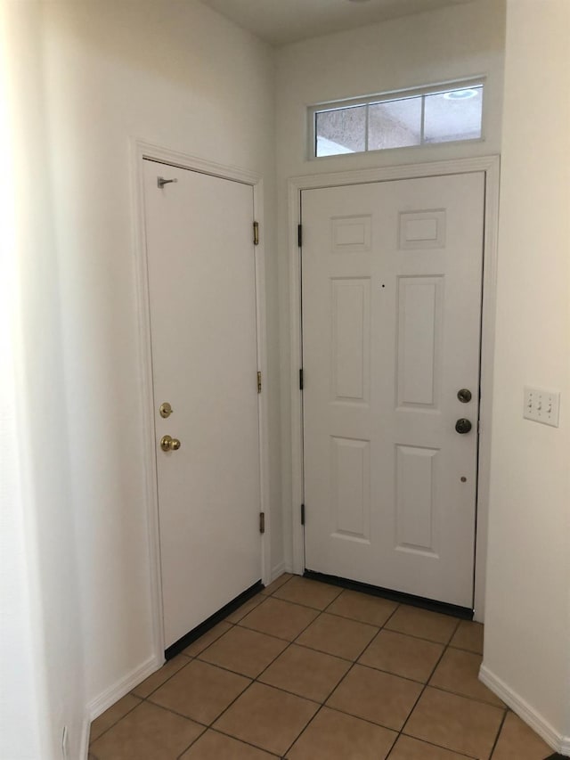 entryway featuring light tile patterned floors and baseboards