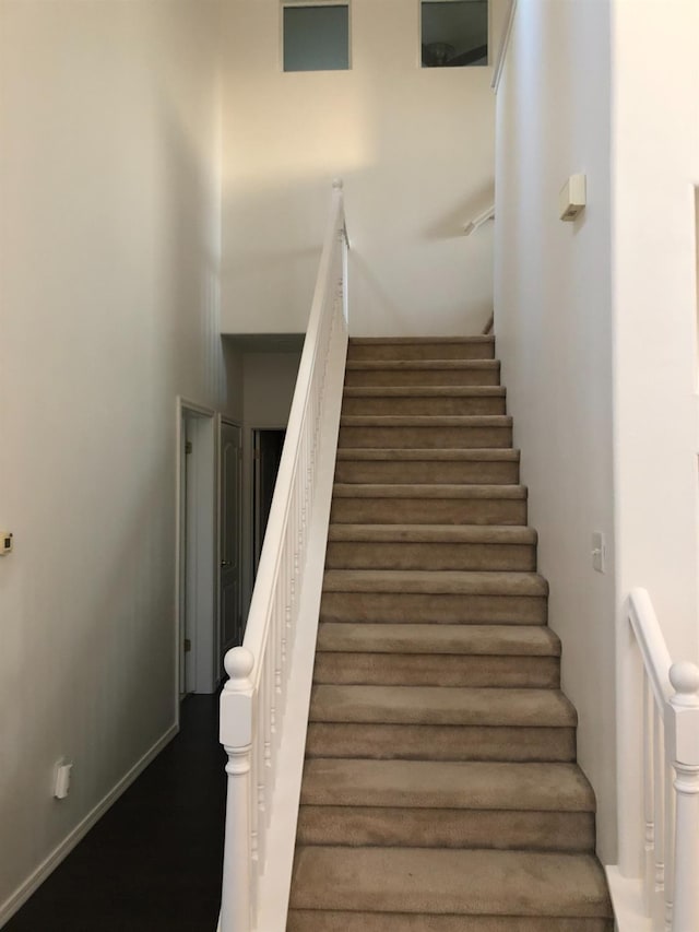 staircase featuring a towering ceiling