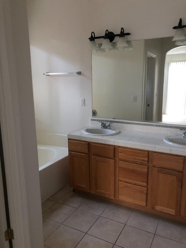 full bathroom with tile patterned flooring, a bathing tub, double vanity, and a sink