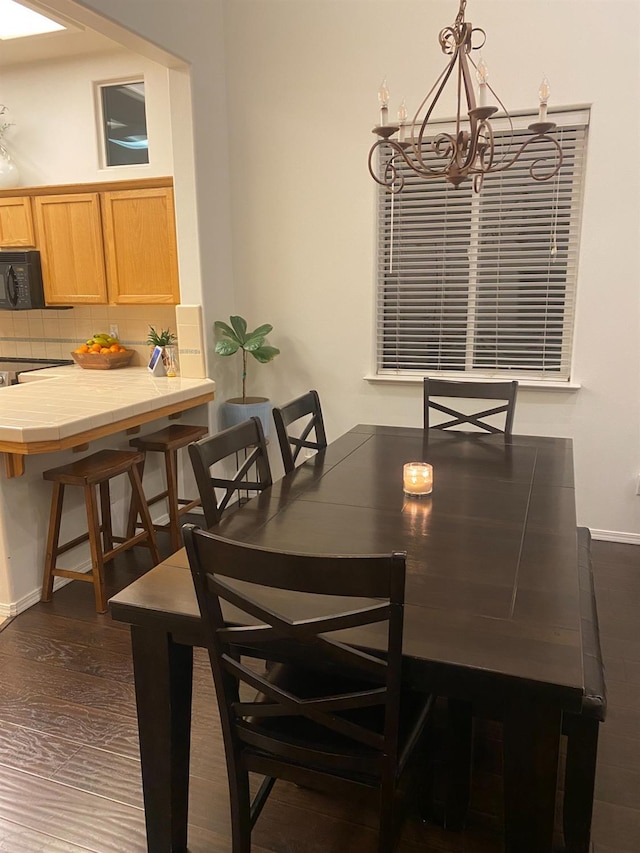 dining area featuring a notable chandelier and dark wood-style floors