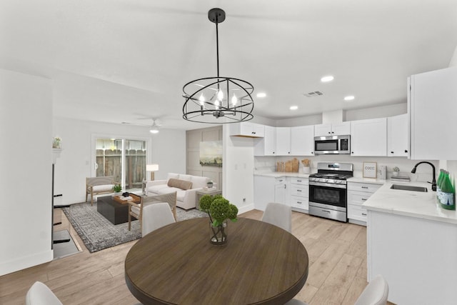 dining area featuring ceiling fan with notable chandelier, light wood-type flooring, visible vents, recessed lighting, and baseboards
