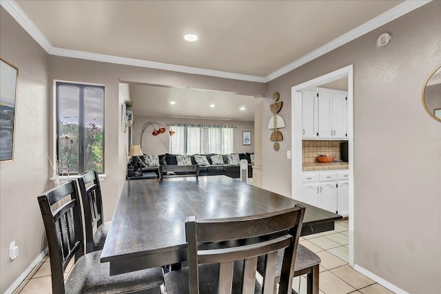 dining room featuring crown molding, baseboards, and light tile patterned floors