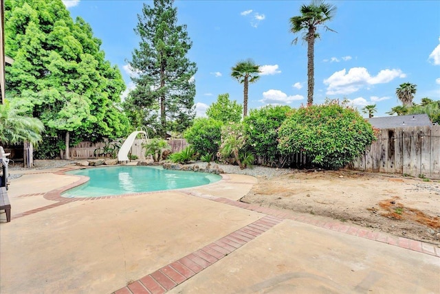 view of swimming pool featuring a patio area, a fenced in pool, a water slide, and a fenced backyard