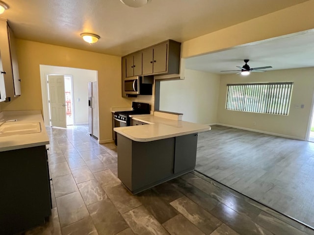 3330 Virginia St, Atwater, CA 95301 - kitchen with ceiling fan, a sink, stainless steel microwave, a peninsula, and light countertops