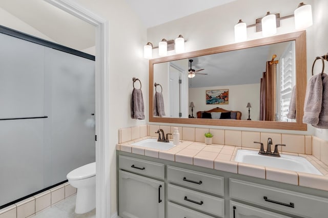 bathroom with a sink, ceiling fan, toilet, and double vanity
