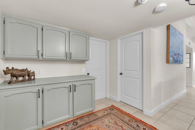 interior space with light countertops, baseboards, and light tile patterned flooring