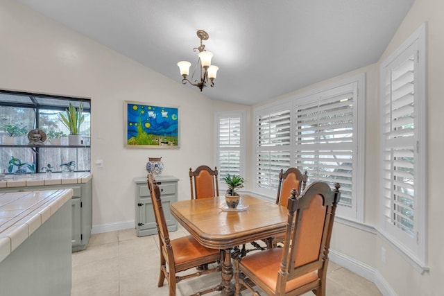 dining room with light tile patterned flooring, lofted ceiling, a healthy amount of sunlight, and a notable chandelier