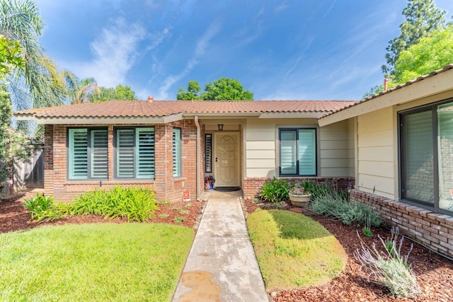 view of front of home featuring a front lawn and brick siding