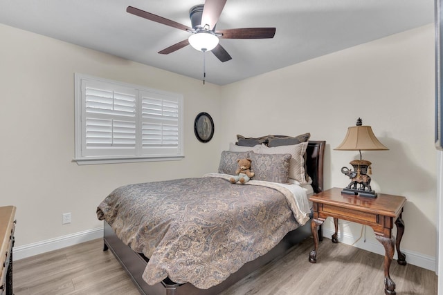 bedroom with baseboards, a ceiling fan, and light wood-style floors
