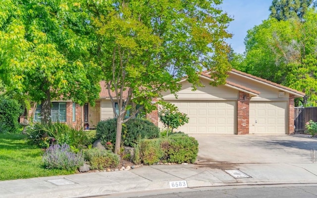 obstructed view of property with concrete driveway, brick siding, and an attached garage