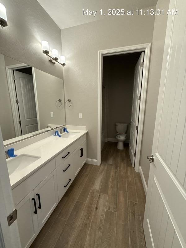 1765 N Whitmore, Clovis, CA 93619 - bathroom featuring a sink, double vanity, baseboards, and wood finished floors