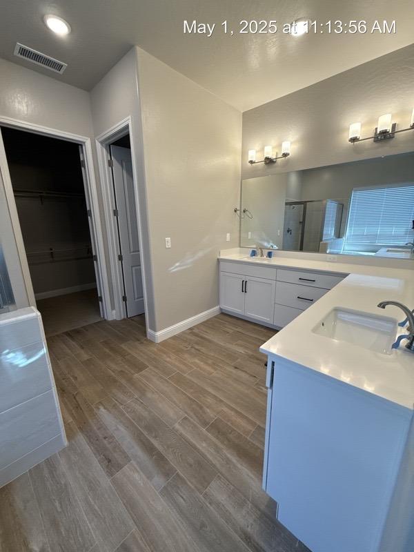 1765 N Whitmore, Clovis, CA 93619 - bathroom with wood finished floors, a sink, two vanities, visible vents, and a shower stall