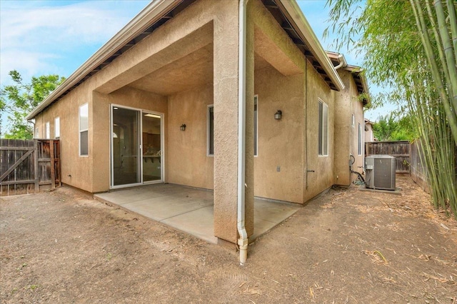 back of house featuring central air condition unit, a patio, stucco siding, and a fenced backyard