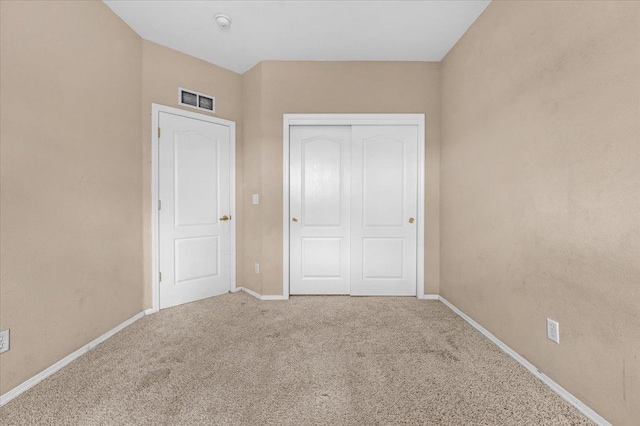 unfurnished bedroom featuring carpet, visible vents, baseboards, and a closet