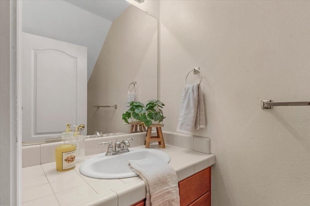 bathroom with vaulted ceiling and vanity