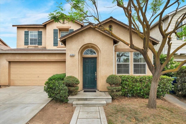 traditional home featuring concrete driveway, stucco siding, and an attached garage