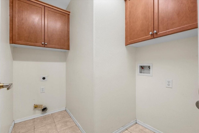 laundry area featuring cabinet space, light tile patterned flooring, electric dryer hookup, washer hookup, and baseboards