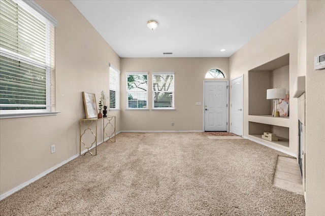 carpeted entryway featuring baseboards