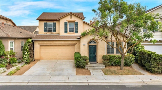 traditional home featuring concrete driveway, an attached garage, stucco siding, and a shingled roof