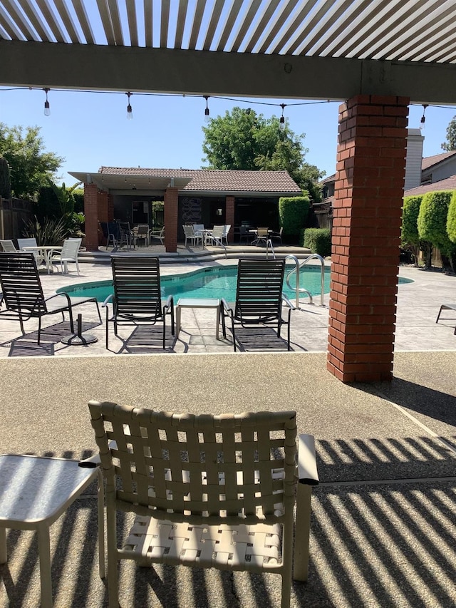 pool with a patio, a pergola, and fence