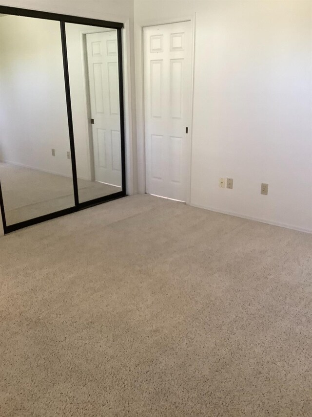 unfurnished bedroom with carpet floors and a closet