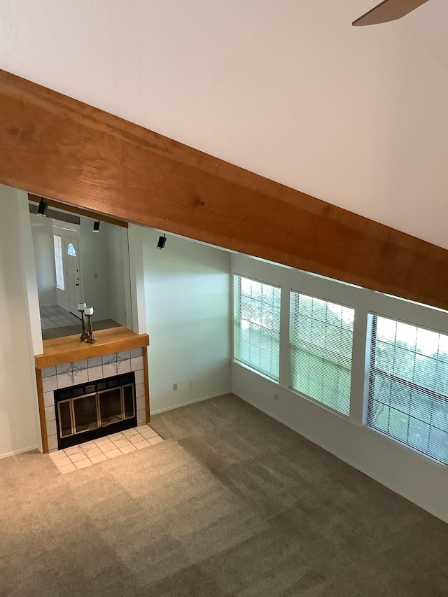 unfurnished living room featuring carpet flooring and a tiled fireplace