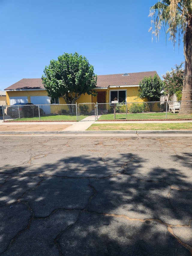view of front of house with stucco siding, a fenced front yard, and a gate