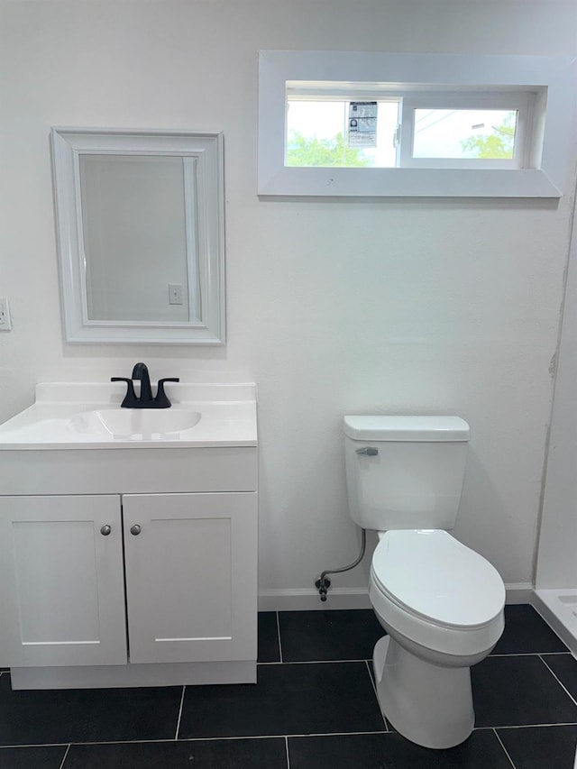 220 S K, Madera, CA 93637 - bathroom with tile patterned floors, toilet, vanity, and a healthy amount of sunlight