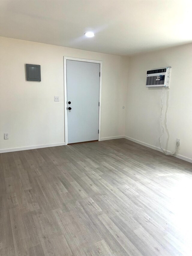 220 S K, Madera, CA 93637 - spare room featuring electric panel, an AC wall unit, baseboards, and wood finished floors